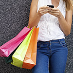 Woman-Texting-with-Shopping-Bags