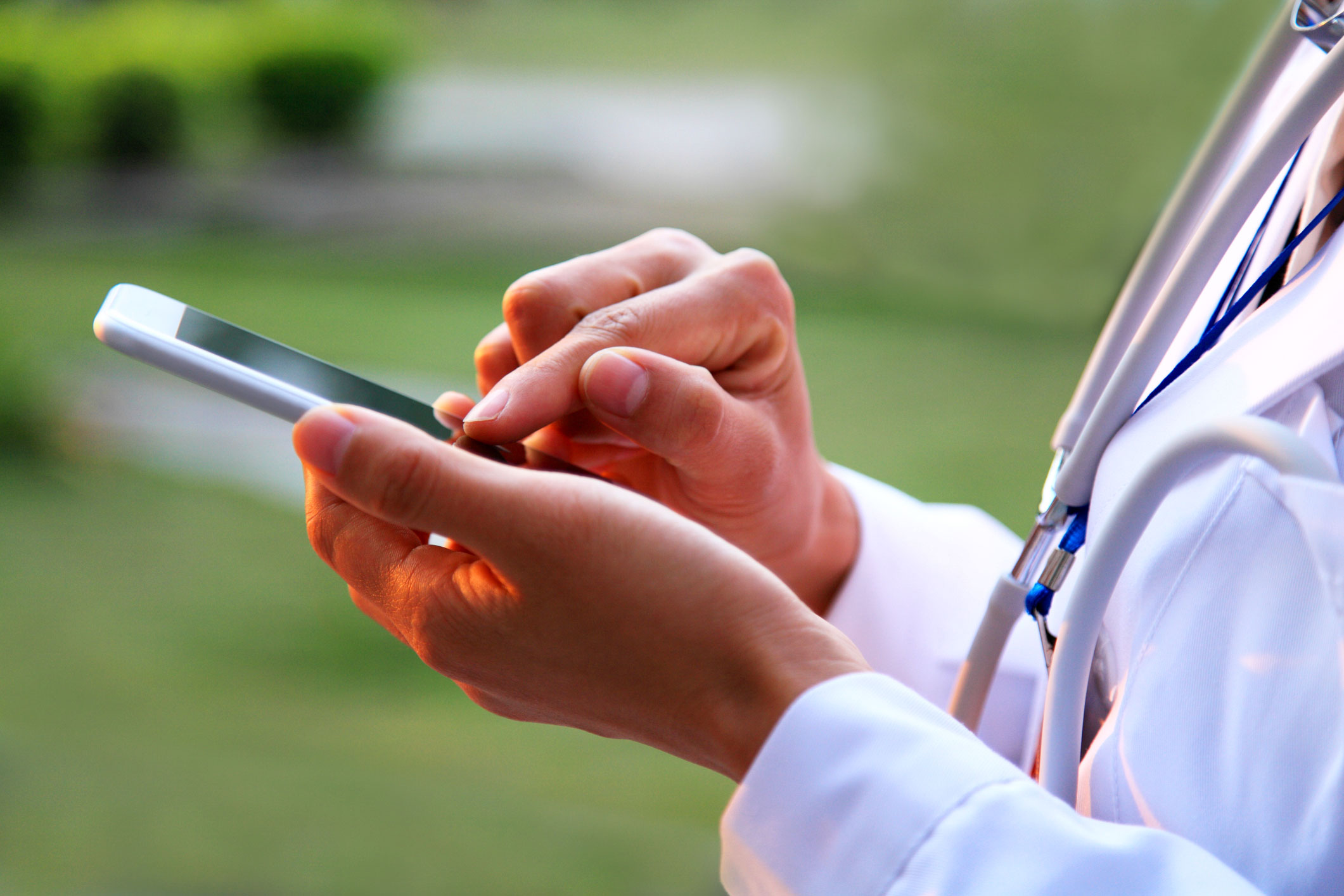Doctor-using-smart-phone-white-coat-and-stethoscope