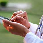Doctor-using-smart-phone,-white-coat-and-stethoscope_thumbnail